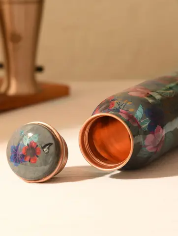 Open bottle with its matching cap and the bare copper inside