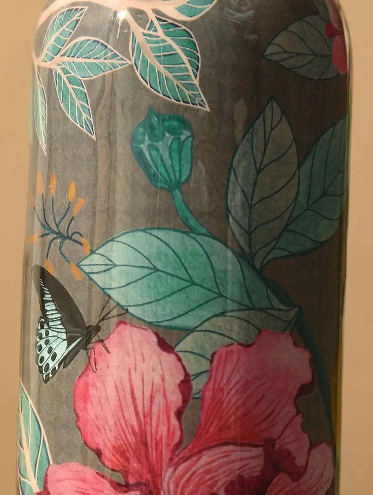 Close view of pink hibiscus, leaves and a butterfly