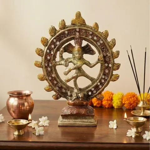The statue on a wooden shelf with a lota, incense and flowers