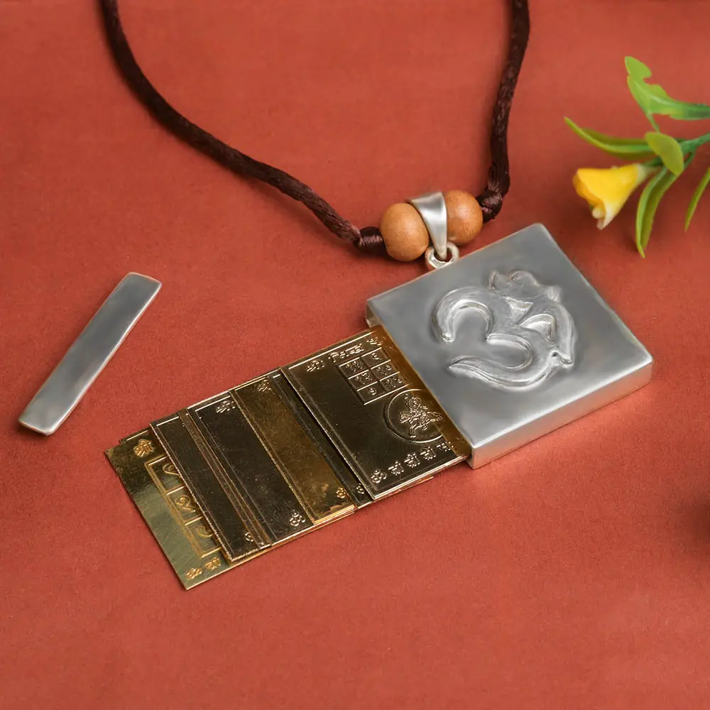 Pendant opened beside its yantra plates