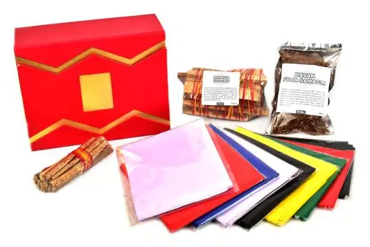 Red box with coloured altar cloths and samidha sticks