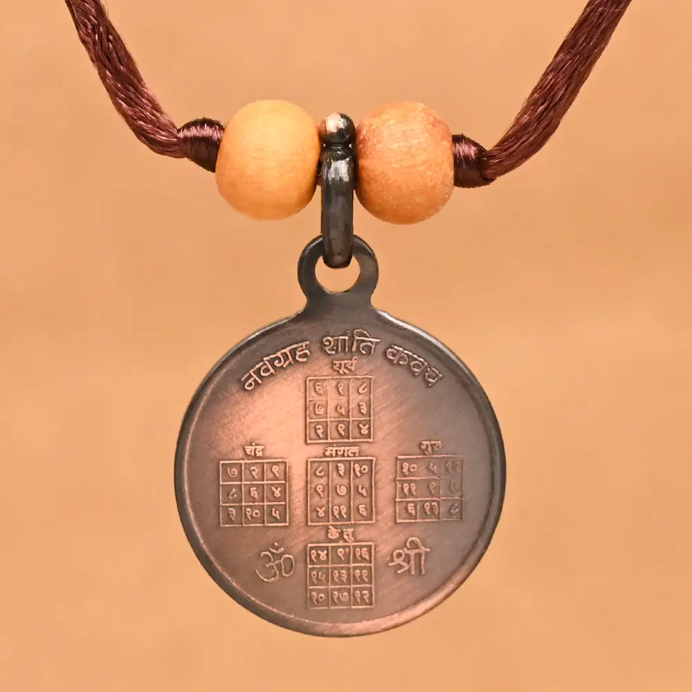 Round copper locket with nine planet yantras on a thread