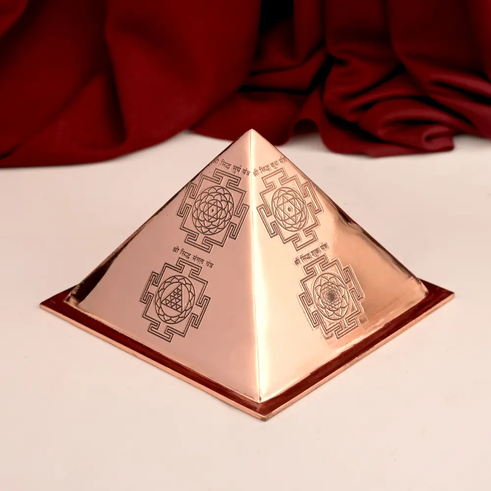 Copper pyramid with engraved yantras on red cloth