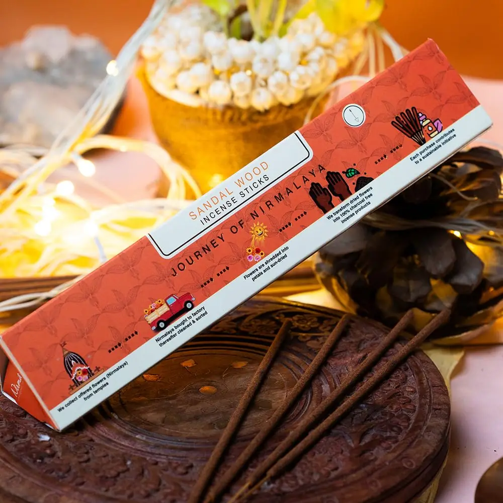 The box open with sticks on a carved wooden stand