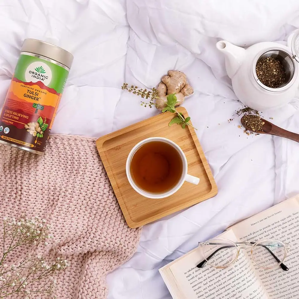 Tin beside a cup of tea on a wooden tray