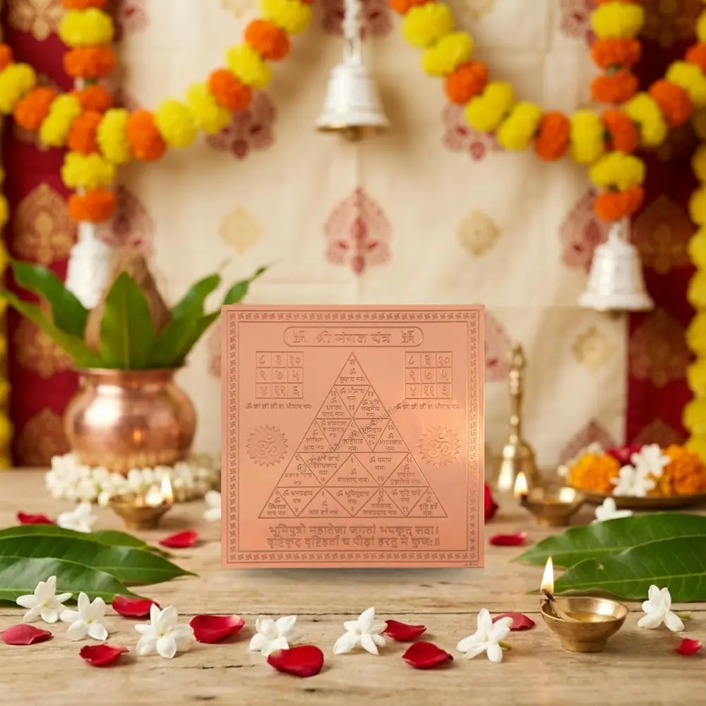The yantra on a puja table with a copper pot and flowers