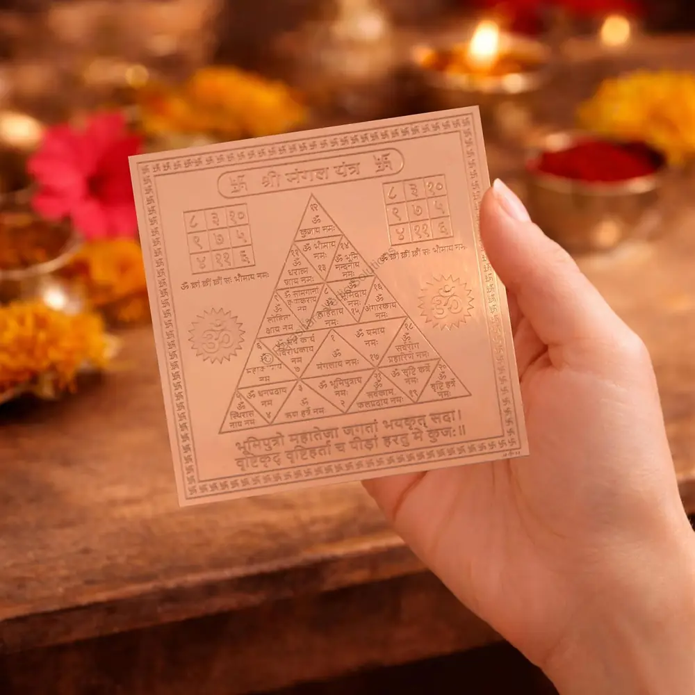 The yantra held in a hand to show its size