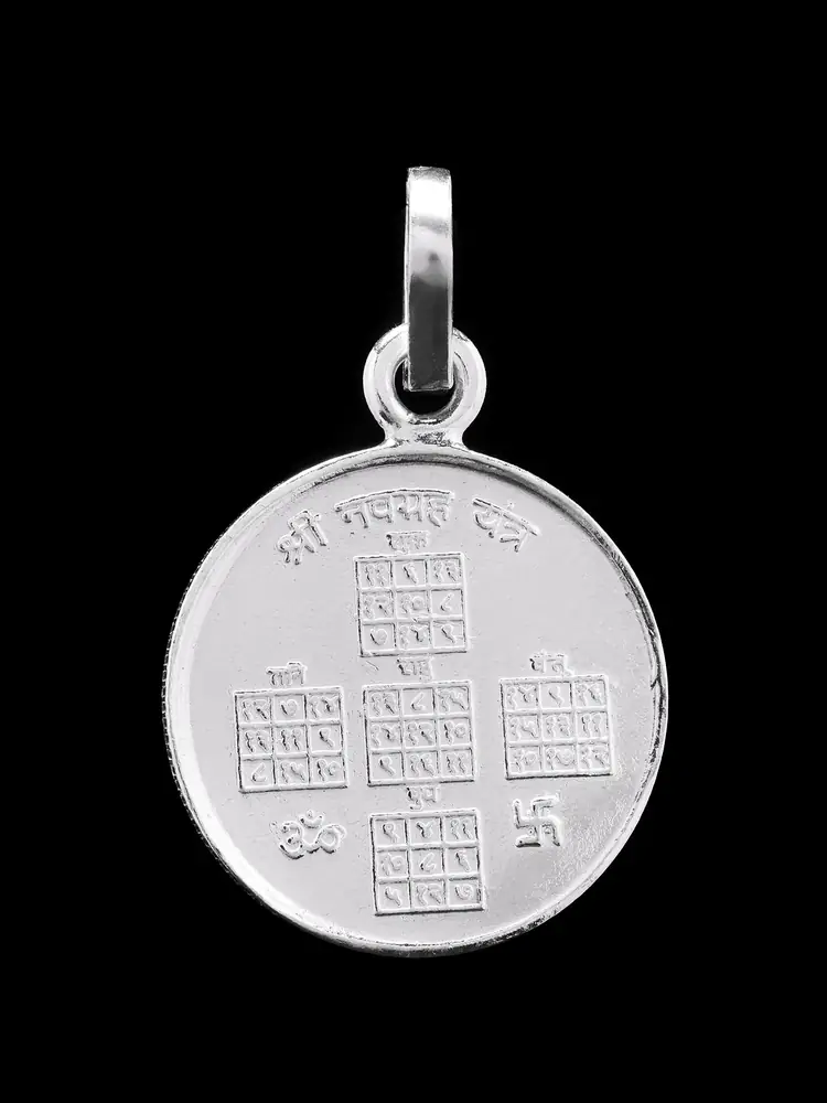 Silver round pendant with a nine cell yantra, close view of one face