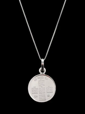 The pendant hanging on a thin chain, one face