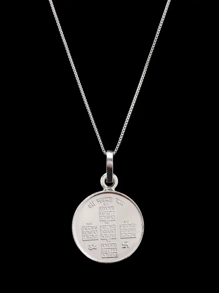 The pendant hanging on a thin chain, one face
