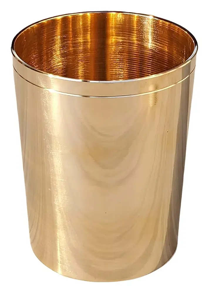 Several kansa glasses on a table with dishes of food