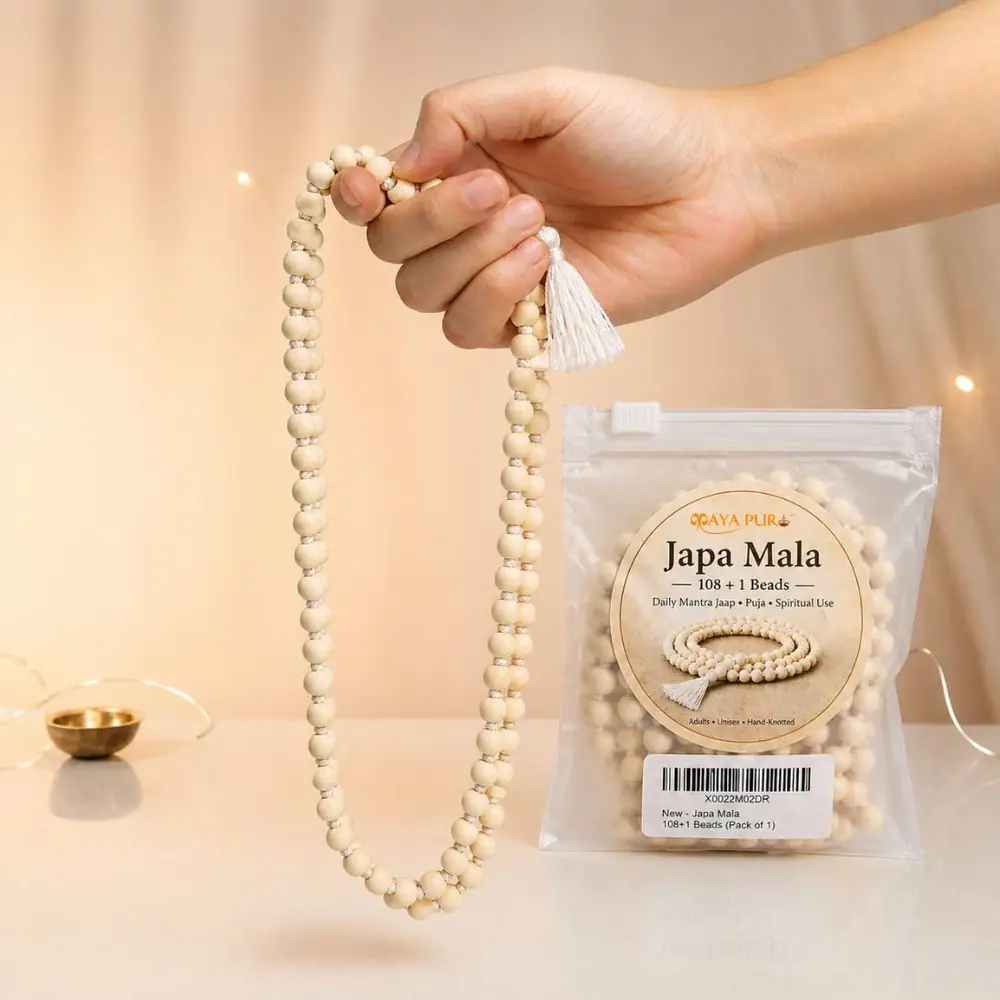 A hand holding the mala up by the guru bead