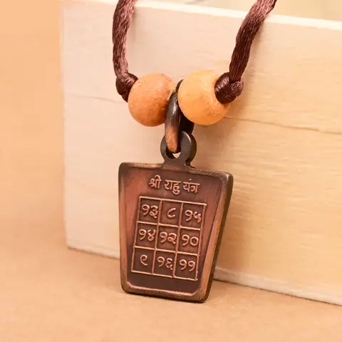 The yantra side on a brown cord with two beads