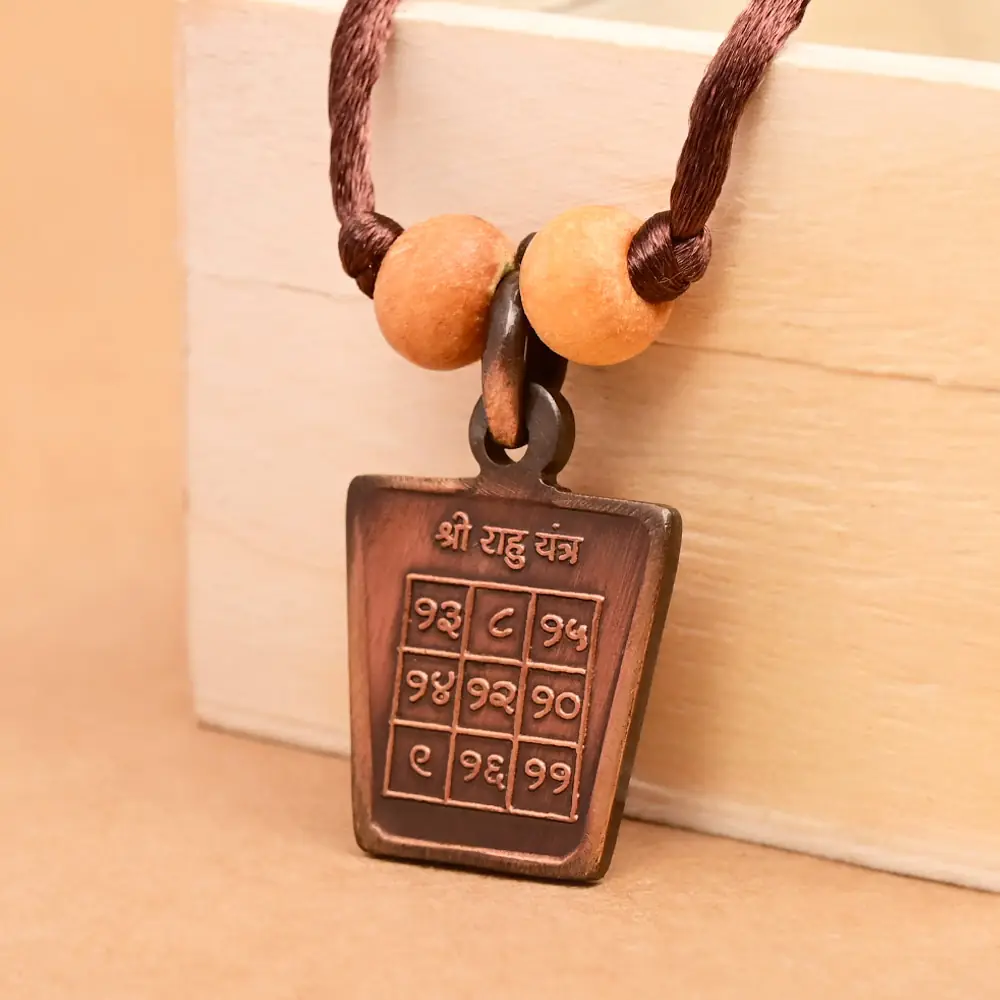 The yantra side on a brown cord with two beads