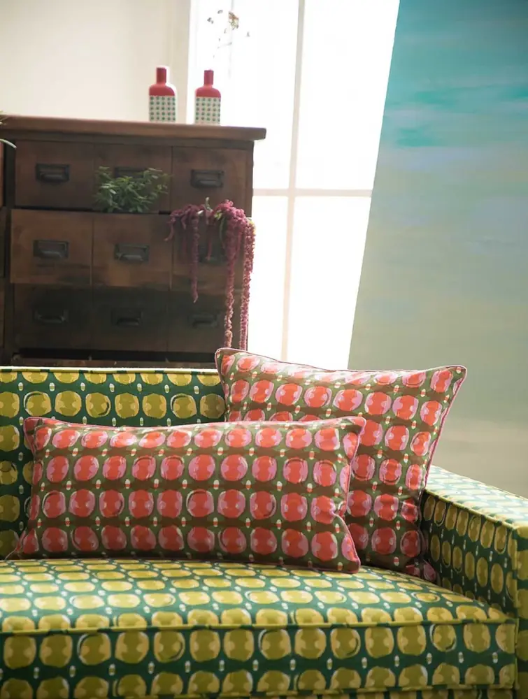 The cover on a sofa near a wooden chest