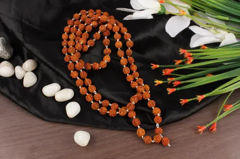 The mala laid in a loop with white stones