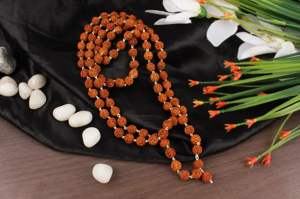 The mala laid in a loop with white stones