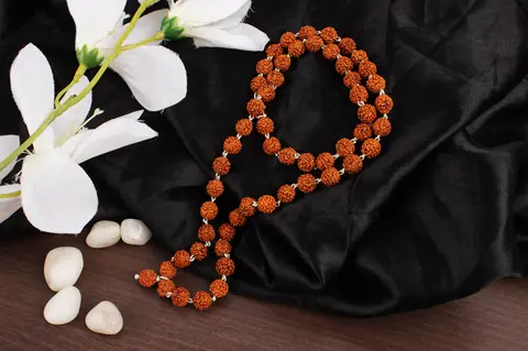 The mala beside white flowers