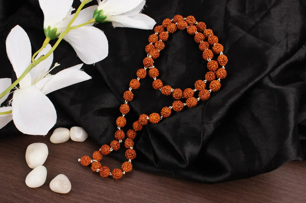 The mala beside white flowers
