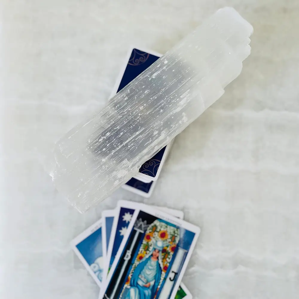 Selenite stick lying on tarot cards