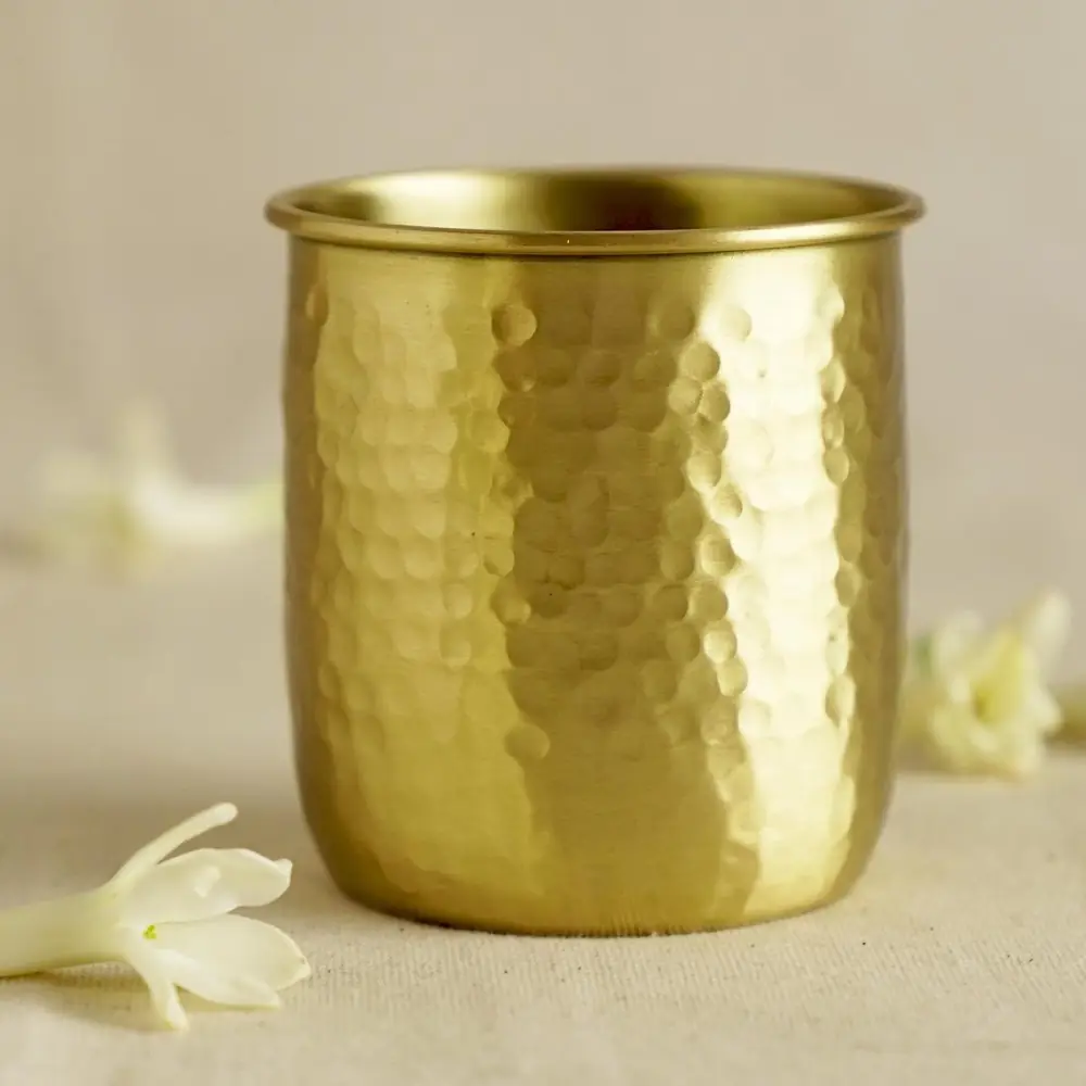 Hammered brass glass seen from above with white flowers