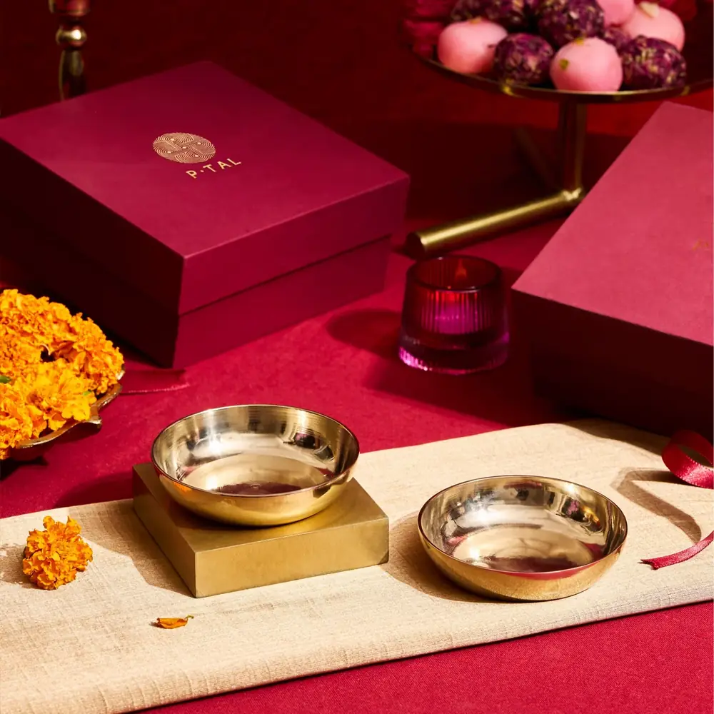 The two bowls on a cream cloth in front of a red gift box