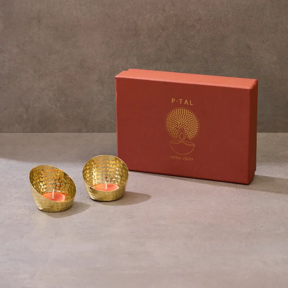 Gift box beside two brass tea light holders