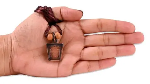 The locket held in an open hand for scale