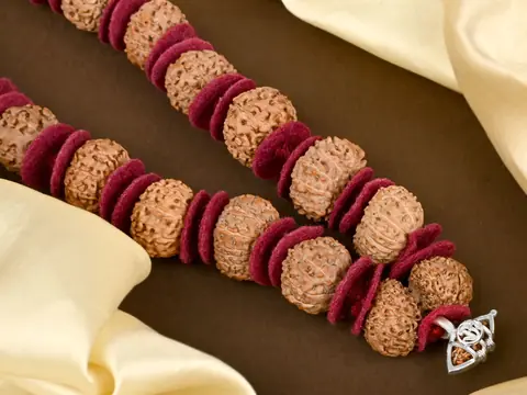 Close view of rudraksha beads between red woollen spacers