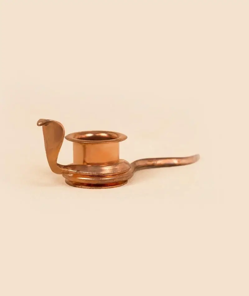 Copper snake dhoop stand on a plain peach ground