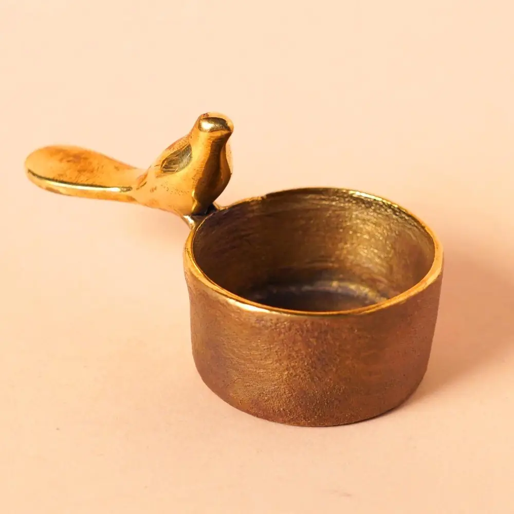 Brass cup with a small bird on the rim