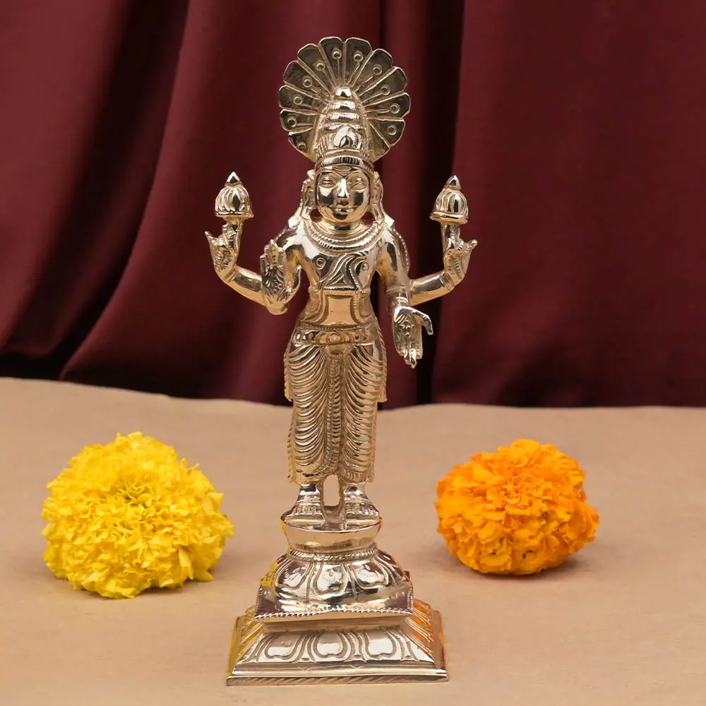 Surya bronze idol standing on its dais with marigolds