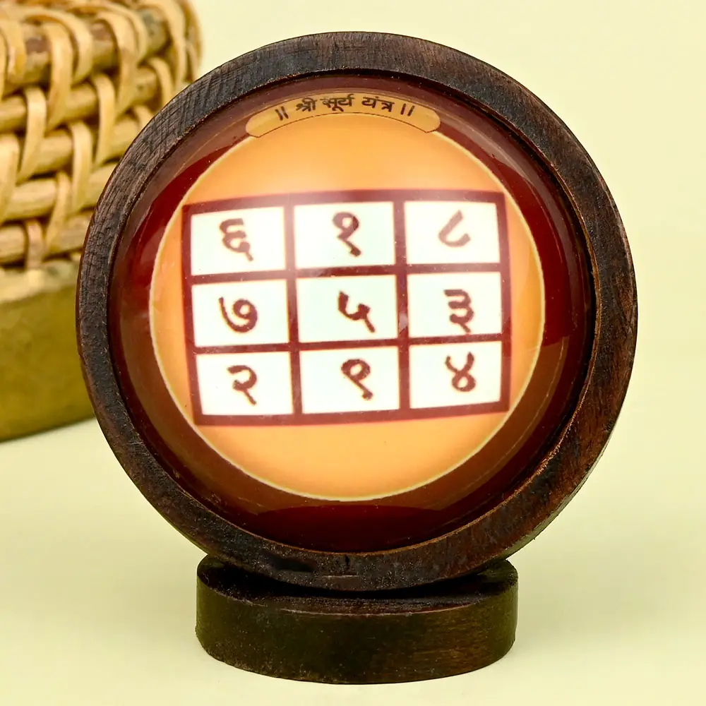 Surya yantra grid in a round wooden frame on a stand
