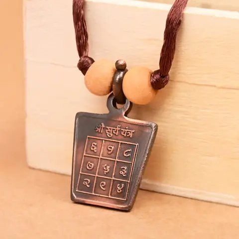 The yantra side on a brown cord with two beads