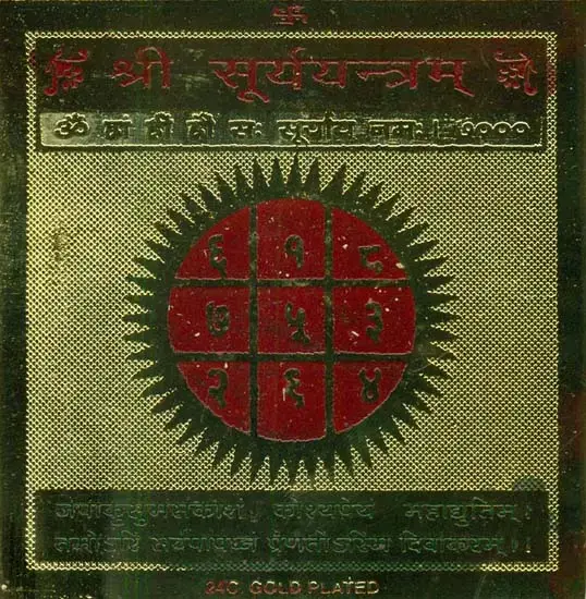 Brass Surya yantra plate with a red sun-shaped grid on dark green