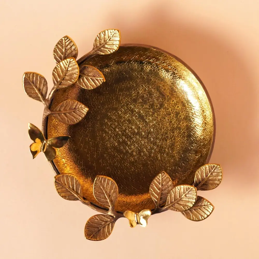 Gold-toned Teak Leaf uruli seen from above with leaves along the rim