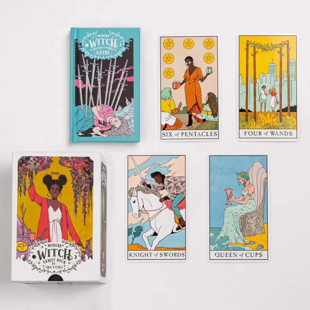 Hands holding the guidebook open beside the cards and box