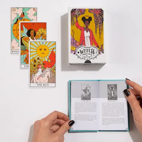 Hands opening the guidebook beside the box