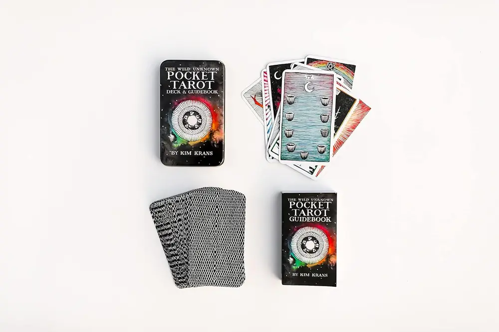 The tin with a stack of cards and a few cards face up