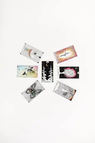 Cards face up beside the tin on a white surface