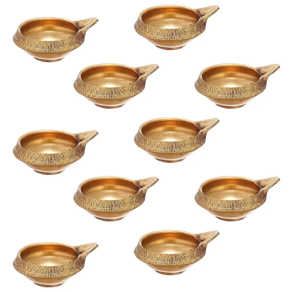Ten brass diyas laid out on a white ground