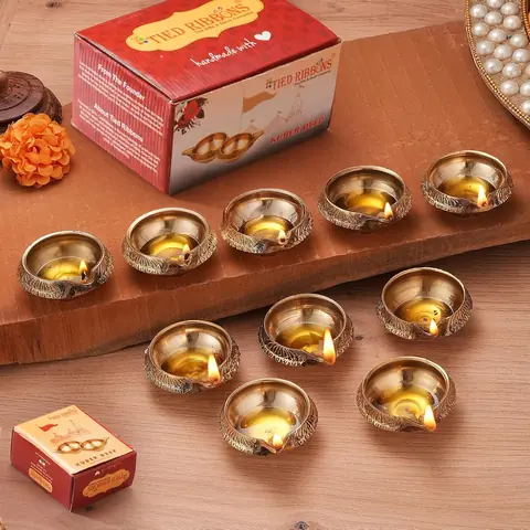 Brass diyas beside their red box