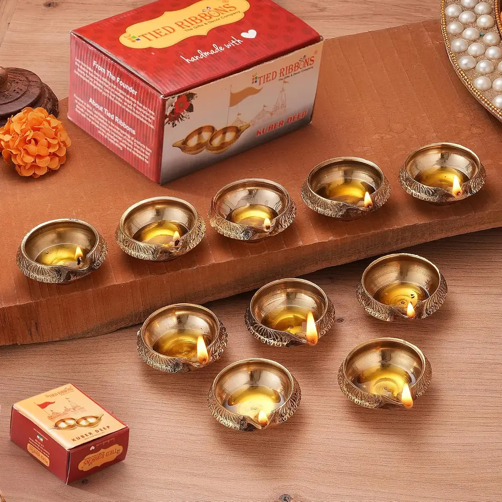 Brass diyas beside their red box