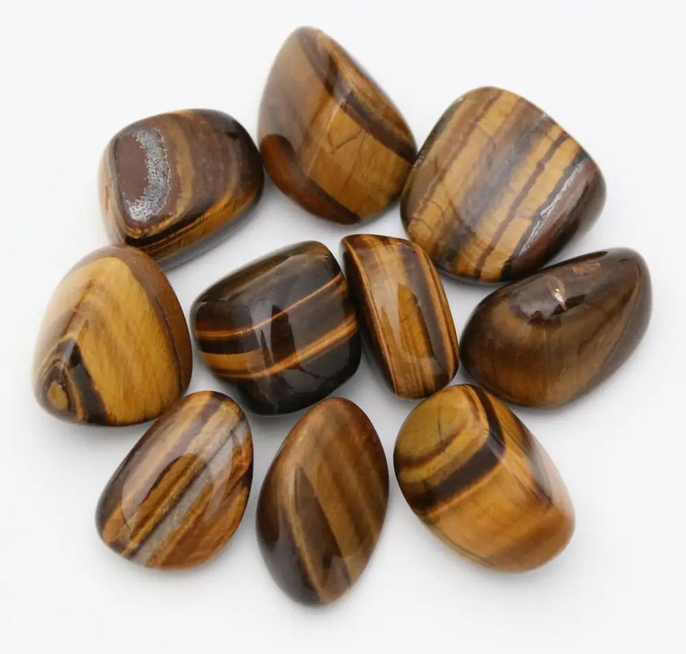 Ten polished tiger's eye stones on a white ground