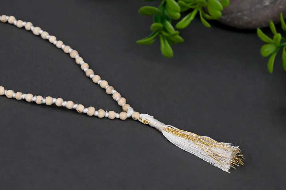 Mala laid out with its tassel on a dark ground