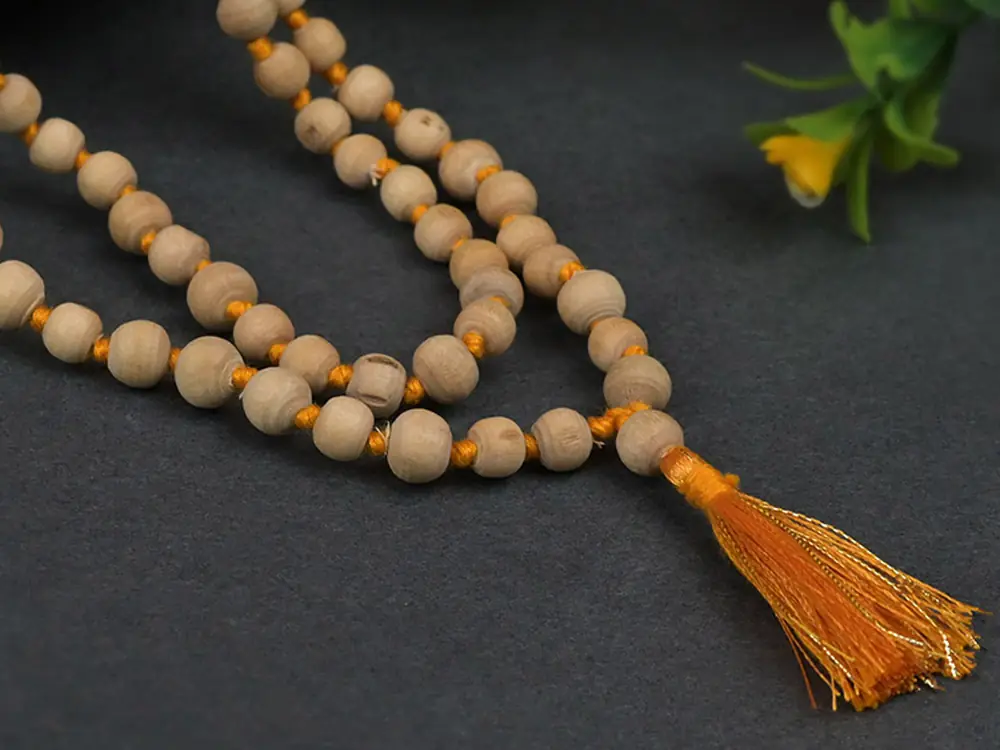 Single tulsi mala in a loop among green leaves