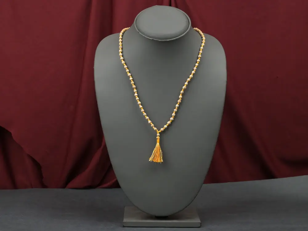Ten tulsi malas with orange tassels in a row