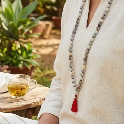 Person wearing the mala over a white shirt