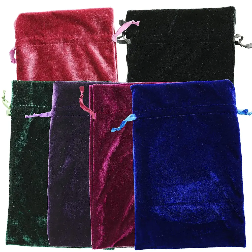 Velvet bags with ribbon drawstrings and loose stones beside them