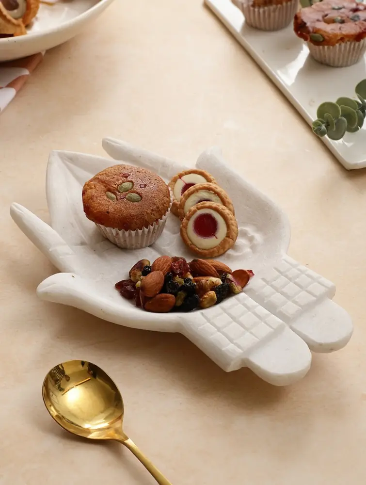 White marble dish holding bangles and a necklace